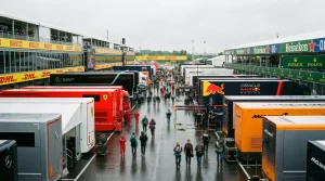 Paddock de Fórmula 1 com logótipos de patrocinadores e gráfico de receitas do Formula One Group